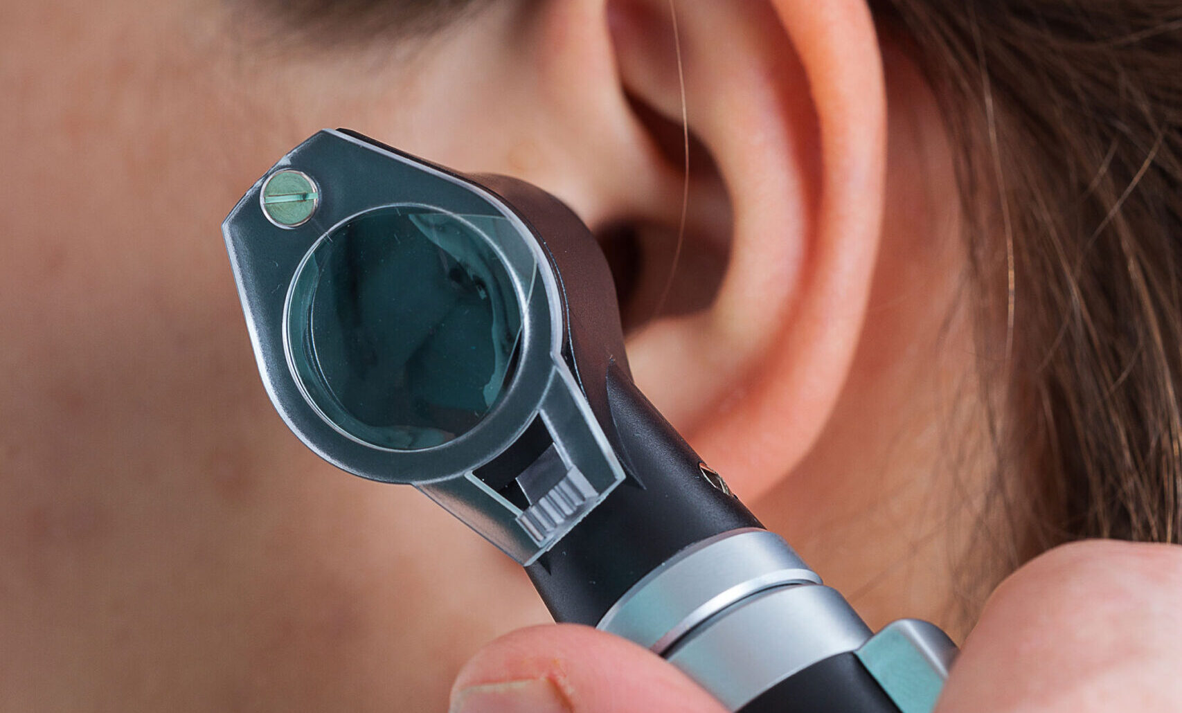 Ear examining with an otoscope, close up